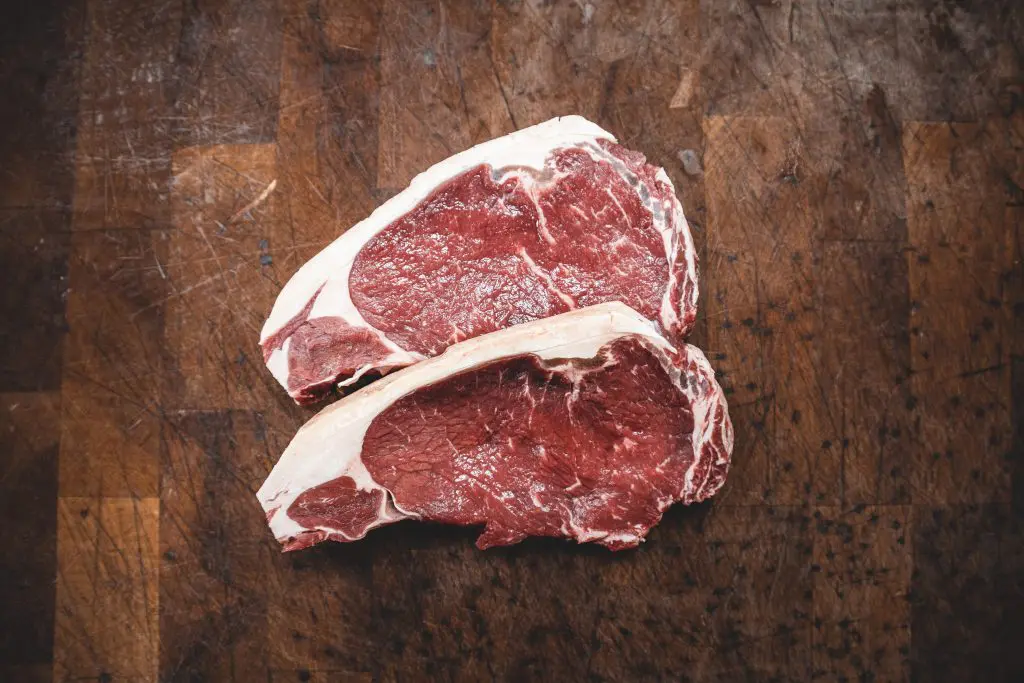 dois pedaços de carne vermelha crua; um alimento rico em vitamina b12